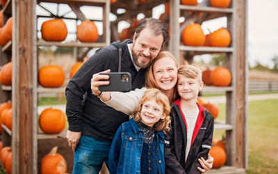 Family Taking Selfie At Pumpkin House