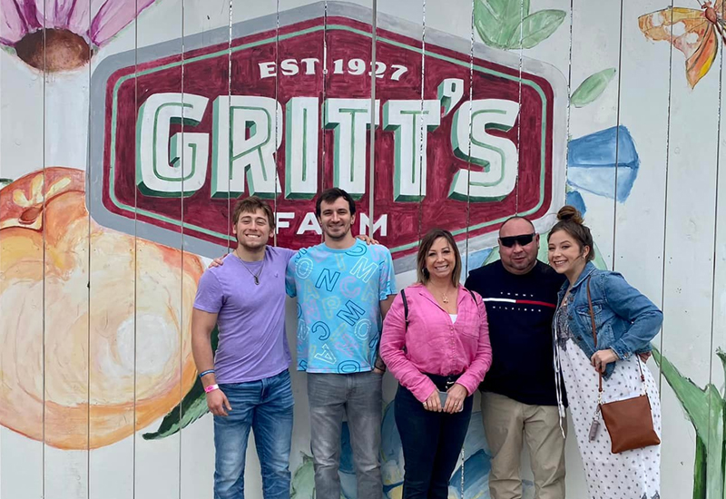 Family Photo In Front of Gritt's Logo